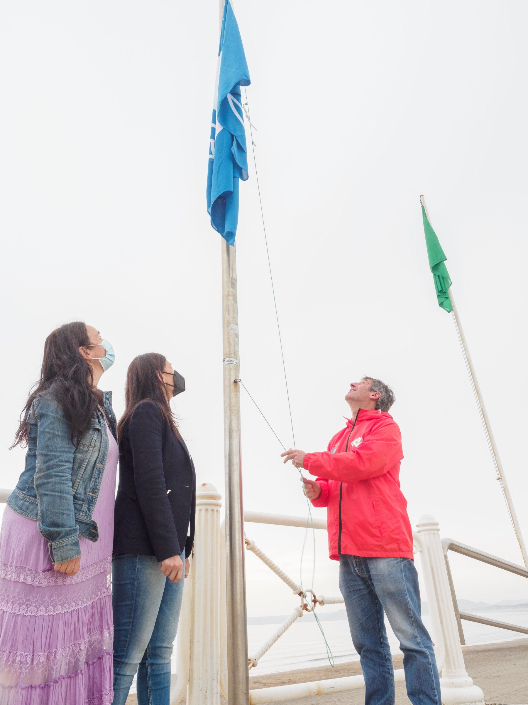 Mar González y Yasmina Triguero observan el izado de la bandera azul. 