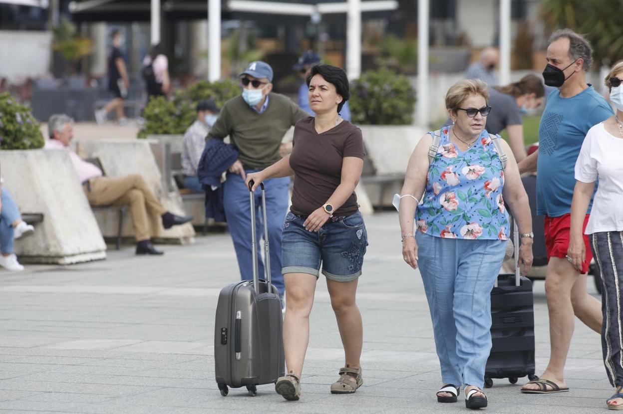 Turistas paseando ayer por Gijón. 