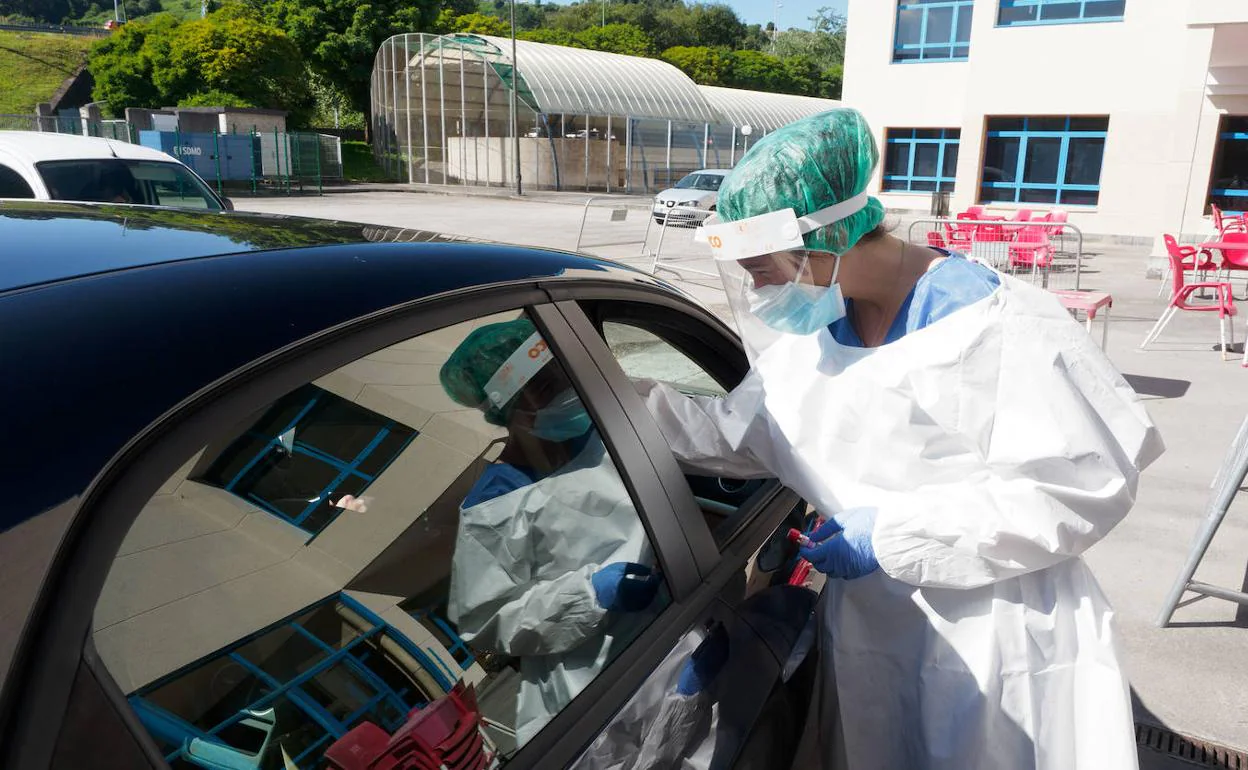 Una sanitaria realiza una PCR este lunes en el autocovid instalado en Los Canapés, en Avilés 