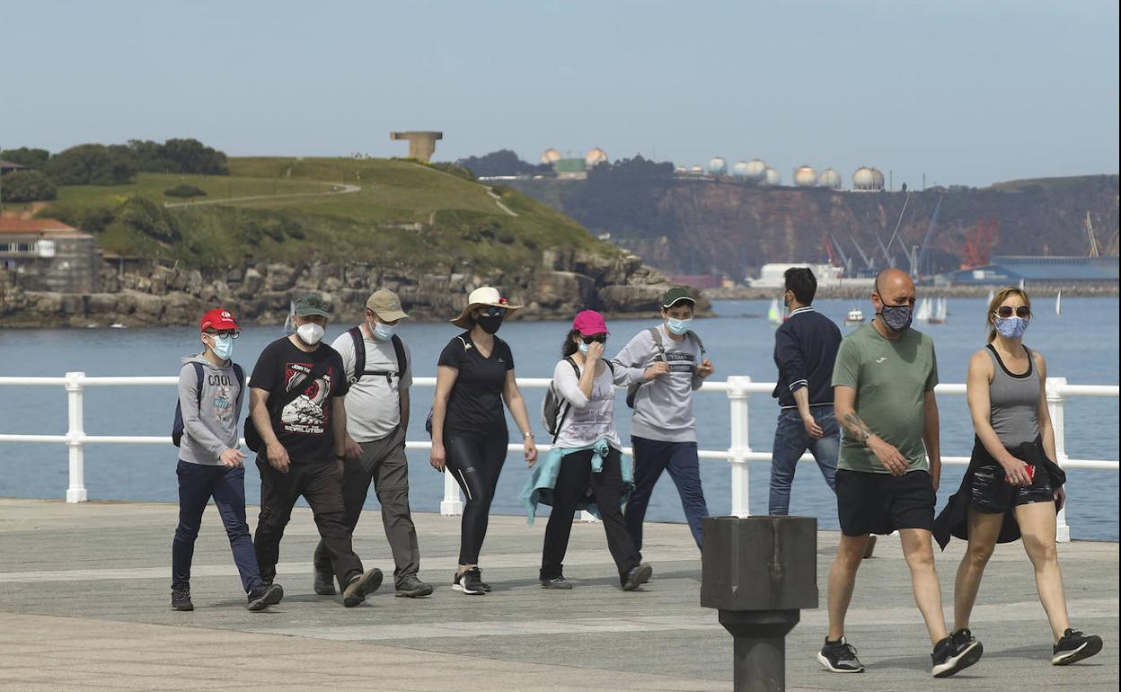 Gente de paseo por El Muro de Gijón
