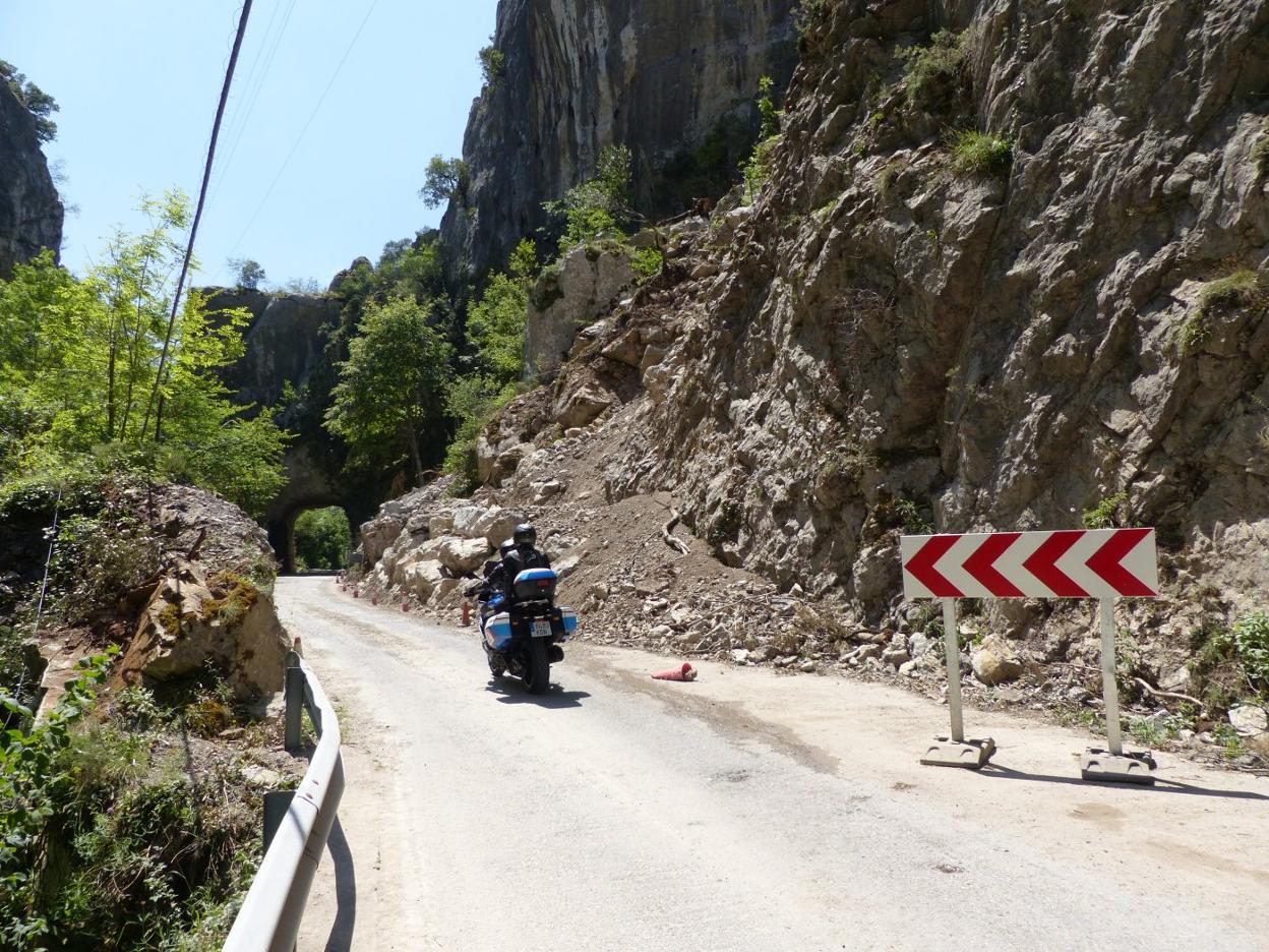 Una moto circula por la carretera AS-227 a la altura del desprendimiento de La Malva, en obras. 