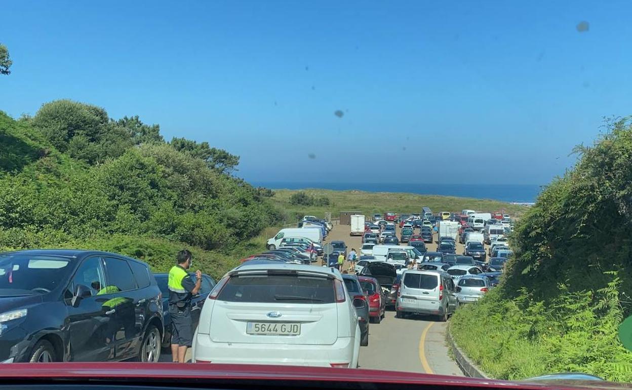 Embotellamiento en el acceso al aparcamiento de la playa de Bayas, ocurrido mediada la mañana del domingo.