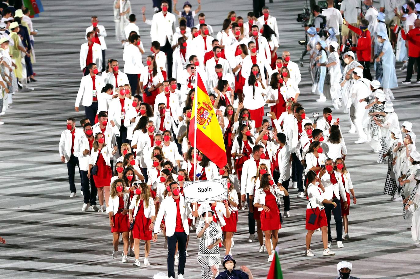 Los Juegos que más se han demorado han dado finalmente arranque tras más de un año. La ceremonia de inauguración, en la que las delegaciones desfilan cada cuatro años ante unas gradas entusiastas, fue en esta ocasión un acto desangelado, debido a la ausencia de público en las competiciones. Sin embargo, algunos rituales se repitieron, como el del encendido del pebetero, uno de los secretos mejor guardados en cada cita y que en esta ocasión consistió en un recipiente esférico inspirado en el Sol. La delegación española, de la que se muestran imágenes, estuvo abanderada por el palista Saúl Craviotto y la nadadora Mireia Belmonte.