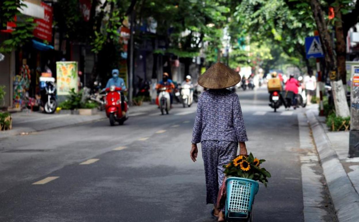 Una mujer pasea por una calle de Hanoi. 