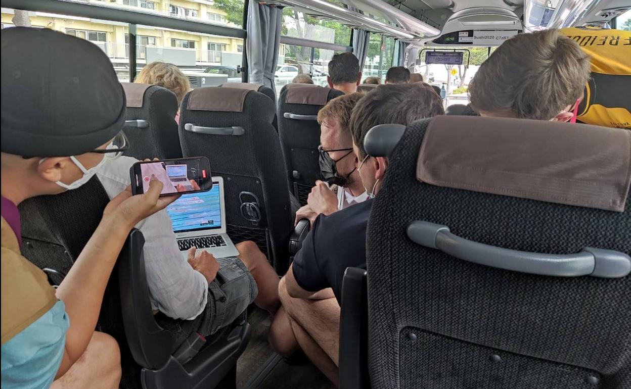 Periodistas, atrapados en el autobús, siguen como pueden la final de los 100 mariposa. 