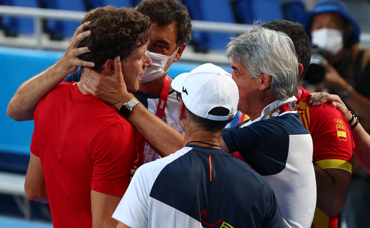 Pablo Carreño recibe el abrazo de su equipo tras su victoria.