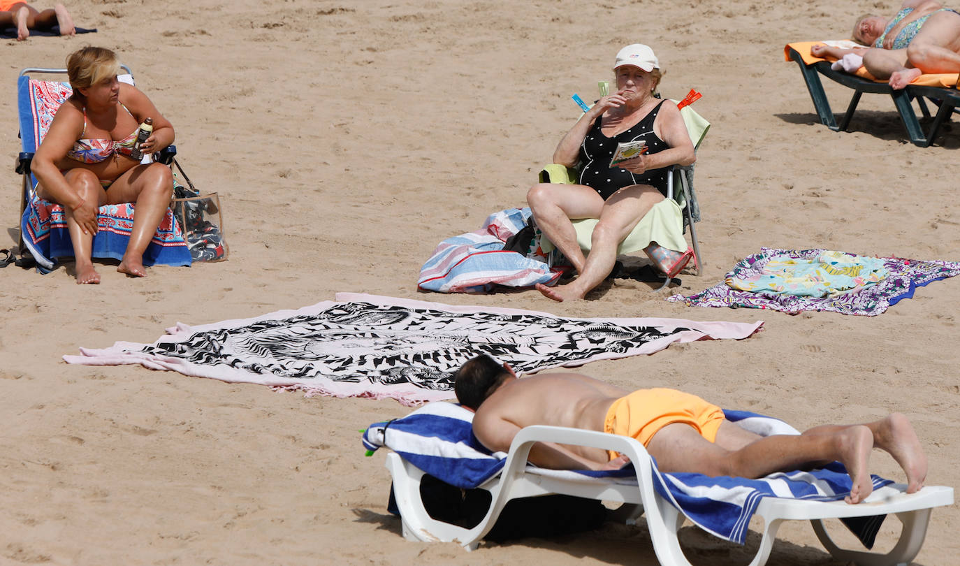 Las temperaturas de este domingo se han quedado lejos de ser las habituales para esta época del año; sin embargo, el sol ha brillado y los gijoneses lo han sabido aprovechar en playas y terrazas 