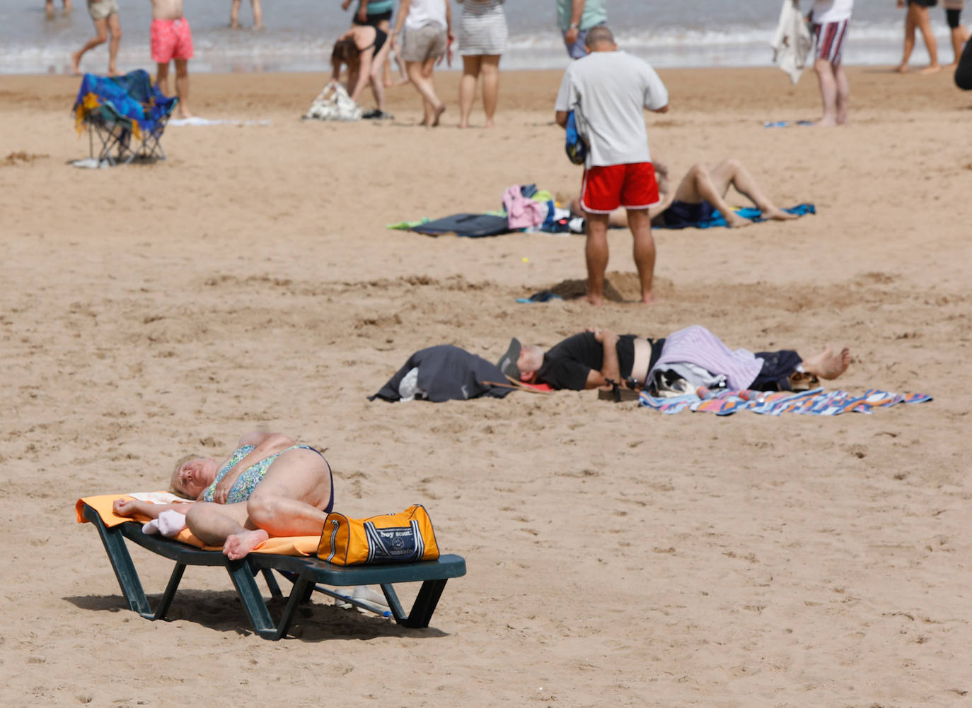 Las temperaturas de este domingo se han quedado lejos de ser las habituales para esta época del año; sin embargo, el sol ha brillado y los gijoneses lo han sabido aprovechar en playas y terrazas 