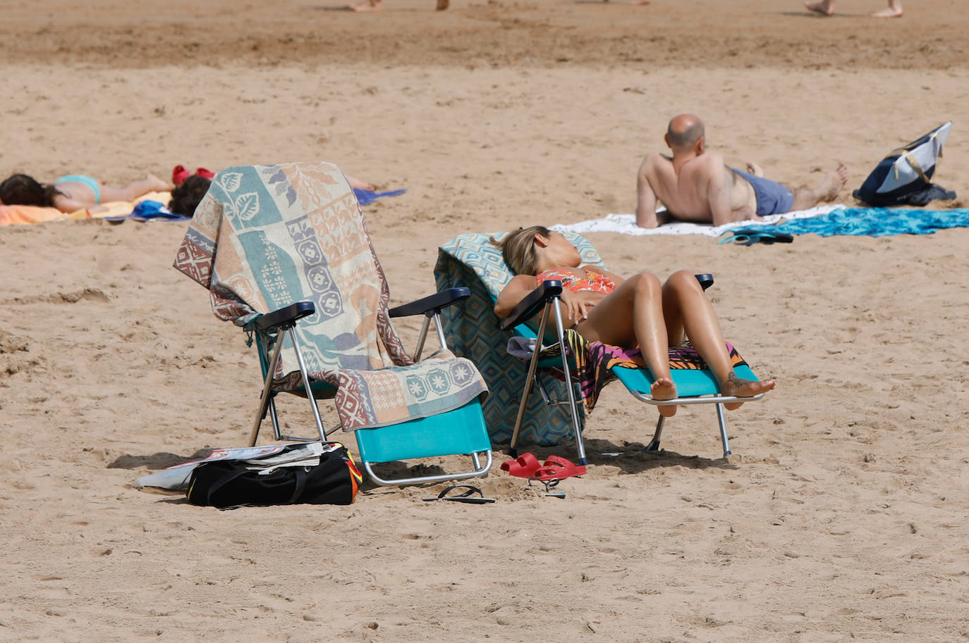 Las temperaturas de este domingo se han quedado lejos de ser las habituales para esta época del año; sin embargo, el sol ha brillado y los gijoneses lo han sabido aprovechar en playas y terrazas 