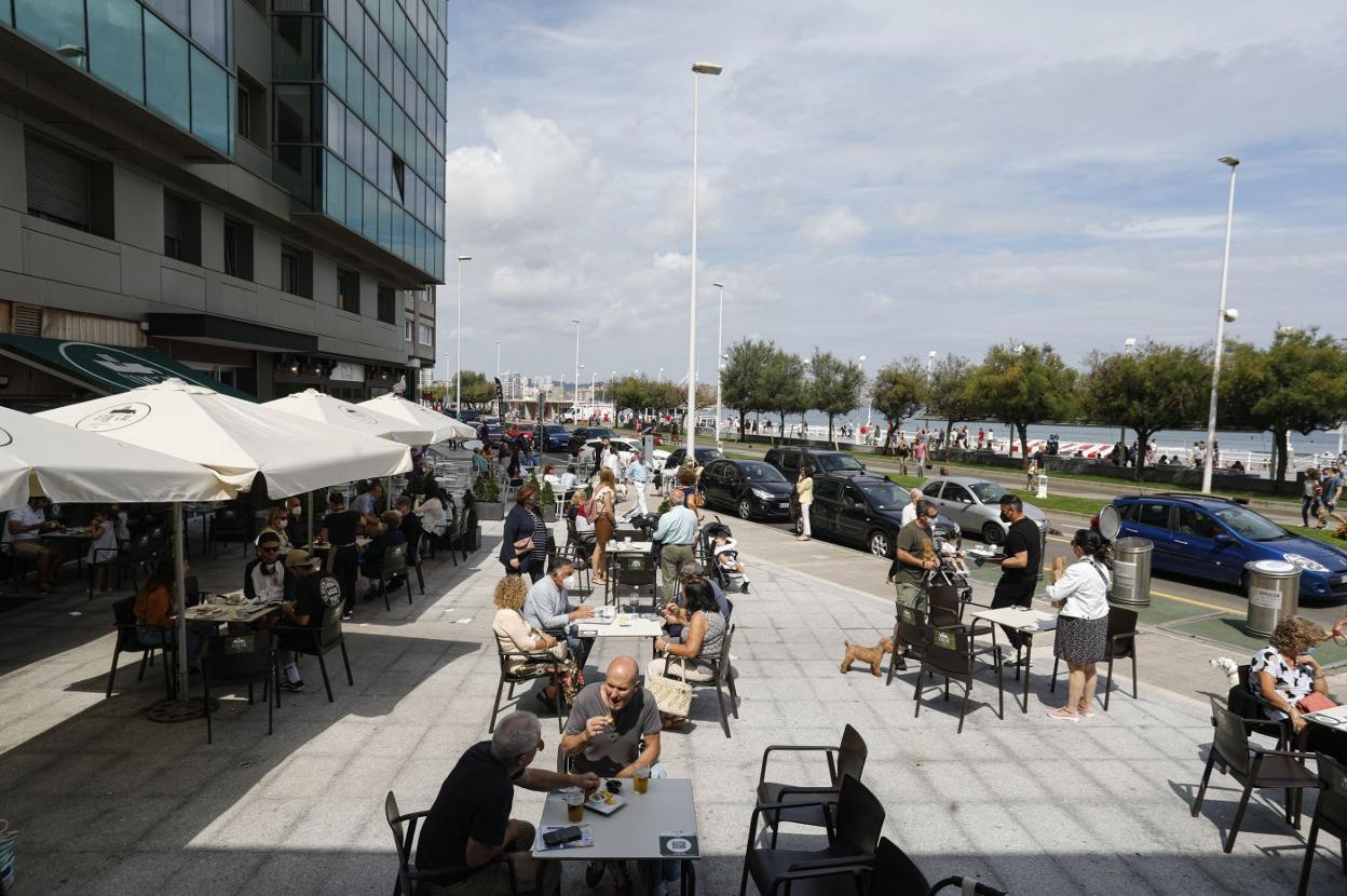 Clientes de un local en el Muro, ayer, toman el vermú en su terraza. 