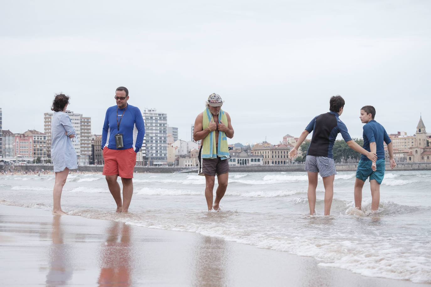 Está siendo un verano atípico en la costa asturiana, pero el mal tiempo no ha impedido que los bañistas se lancen a la playa de San Lorenzo con ganas de disfrutar del día. Algunos pasean, otros leen con la ropa puesta y los más valientes se atreven a darse un chapuzón. Cualquier plan es preferible a quedarse en casa.