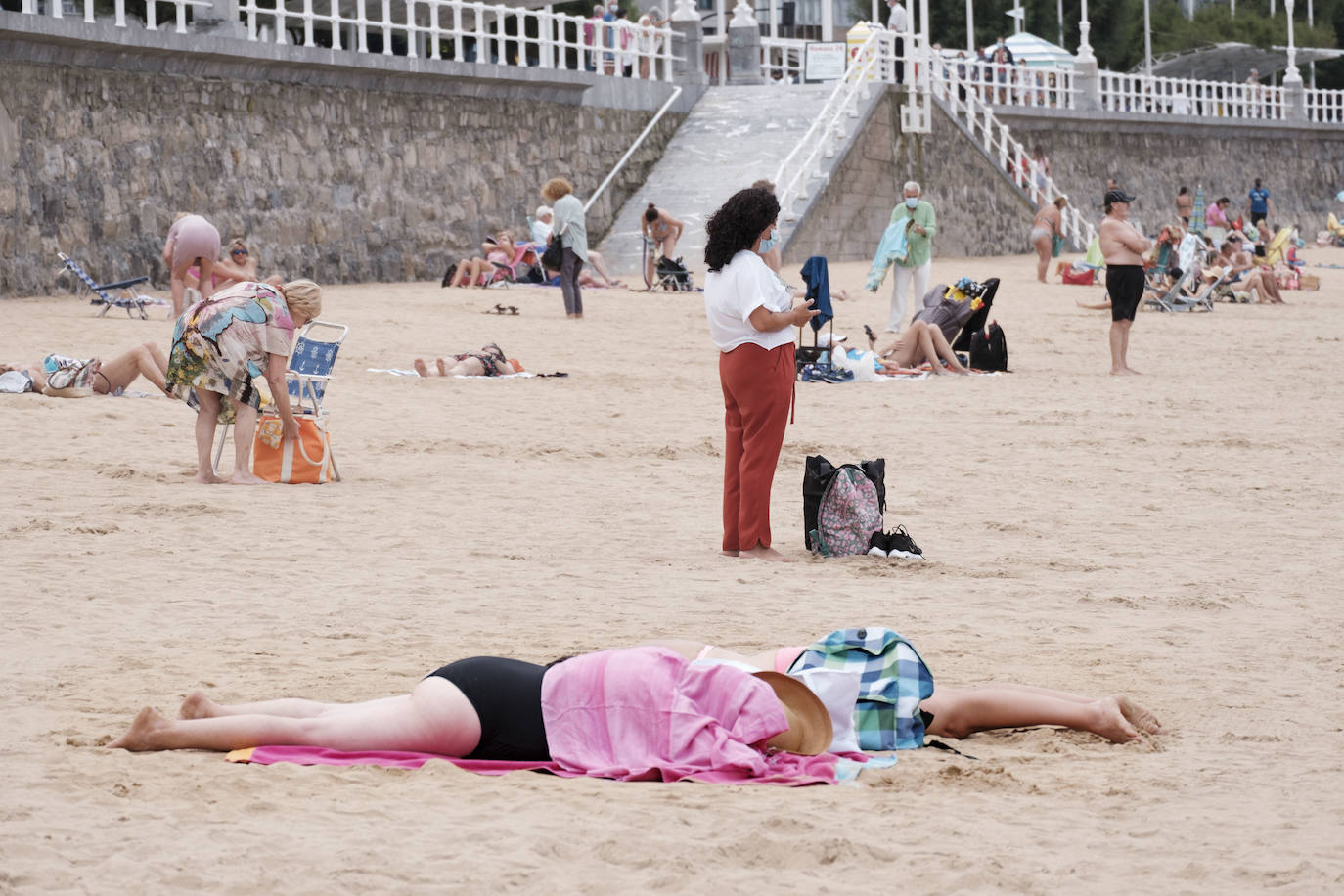 Está siendo un verano atípico en la costa asturiana, pero el mal tiempo no ha impedido que los bañistas se lancen a la playa de San Lorenzo con ganas de disfrutar del día. Algunos pasean, otros leen con la ropa puesta y los más valientes se atreven a darse un chapuzón. Cualquier plan es preferible a quedarse en casa.