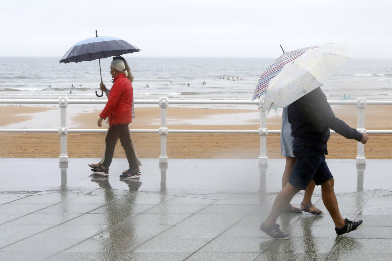 Está siendo un verano atípico en la costa asturiana, pero el mal tiempo no ha impedido que los bañistas se lancen a la playa de San Lorenzo con ganas de disfrutar del día. Algunos pasean, otros leen con la ropa puesta y los más valientes se atreven a darse un chapuzón. Cualquier plan es preferible a quedarse en casa.