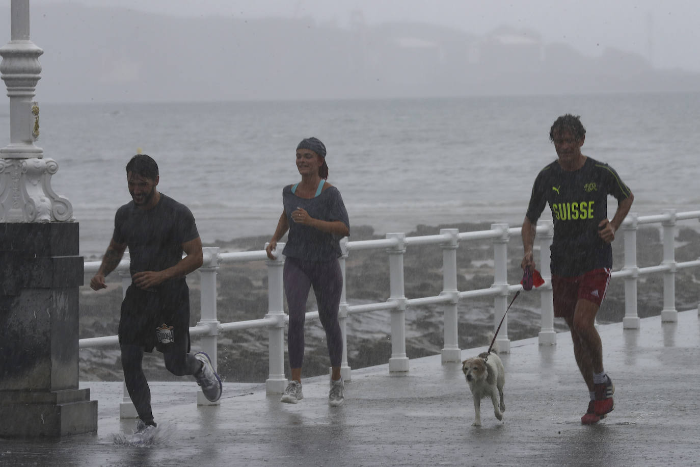 Está siendo un verano atípico en la costa asturiana, pero el mal tiempo no ha impedido que los bañistas se lancen a la playa de San Lorenzo con ganas de disfrutar del día. Algunos pasean, otros leen con la ropa puesta y los más valientes se atreven a darse un chapuzón. Cualquier plan es preferible a quedarse en casa.