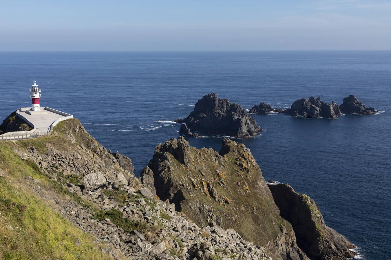 Cabo de Ortegal: Este cabo situado en la costa atlántica española y dentro del municipio de Cariño, perteneciente a La Coruña, es otra simbólica marca divisoria entre las aguas del océano Atlántico y el mar Cantábrico y uno de esos miradores a la costa que no deberías perderte. Un mirador en el que podrás asomarte a esos paisajes infinitos repletos de imponentes acantilados y aguas azules que se combinan en un mismo plano.