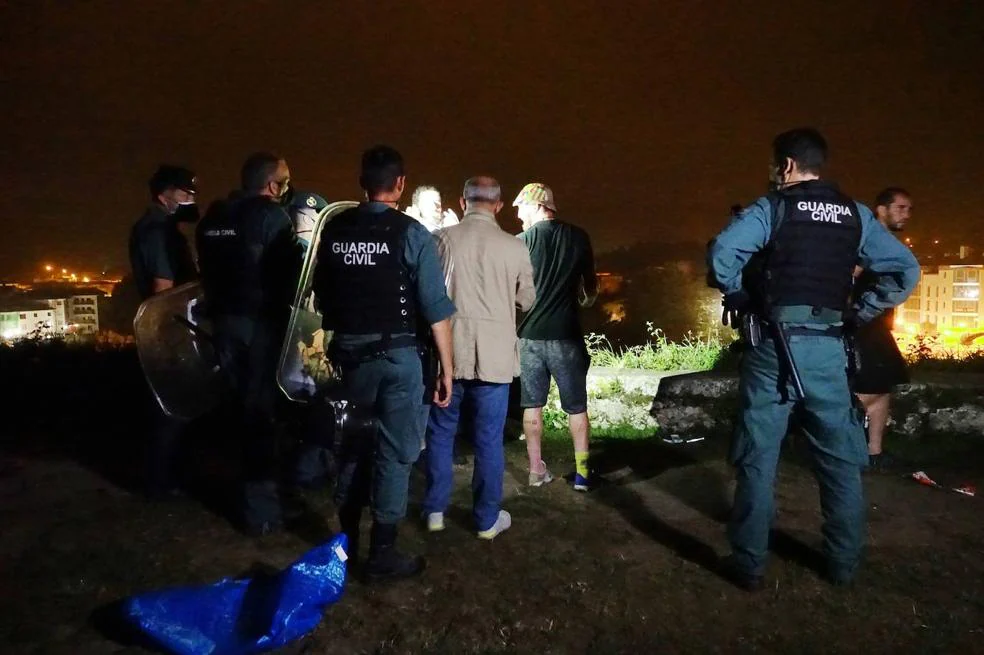 Agentes de la Guardia Civil disuelven a los participantes en el botellón que tuvo lugar en la madrugada del ayer en el paseo de San Pedro, en Llanes. 