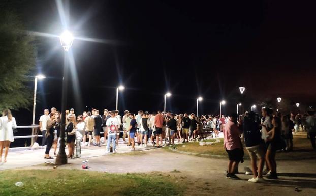 En la imagen, jóvenes congregados en el paseo de la playa de Luanco esta madrugada | En el vídeo, el ambiente que se vivía este viernes en Luarca 