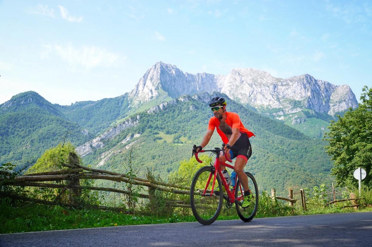 Un ciclista en la ruta que realizará la Vuelta, ascendiendo hacia San Juan de Beleño con el pico Tiatordos al fondo. 