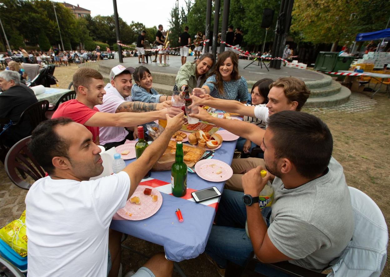 Uno grupo de amigos comparten mantel en la comida en la calle por Santa Isabel. 