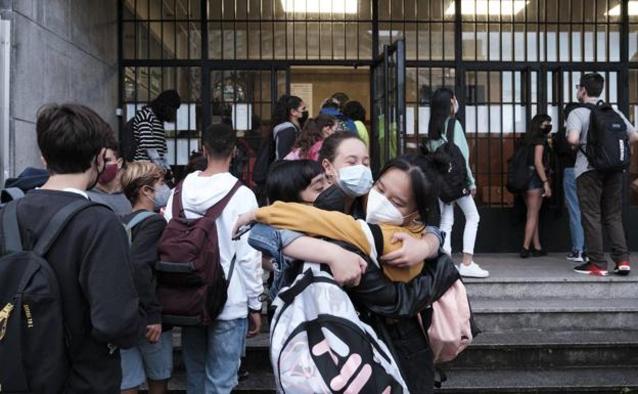 Tres alumnas del IES Doña Jimena se abrazan al reencontrarse a las puertas del centro. 