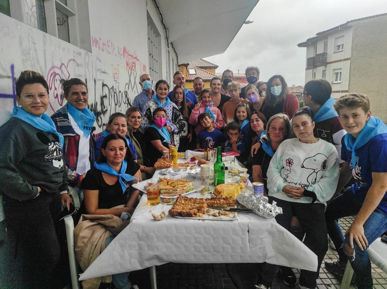 El grupo de amigas Les Culebres junto con parejas, amigos e hijos bajo los aleros de la Sala Polivalente La Plaza. 