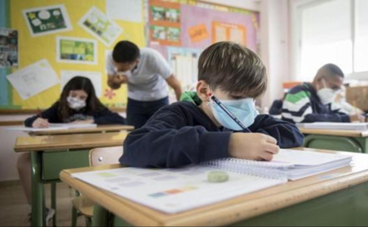 Varios alumnos estudian en clase con medidas de seguridad. 