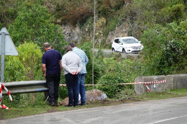 Varias personas contemplan en punto en el que fallecieron los dos participantes del rally. 