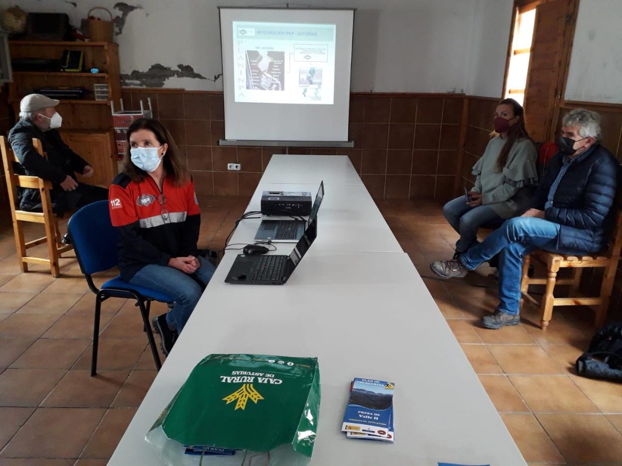 Una técnica del SEPA indica el protocolo de emergencia a los vecinos ante el alcalde, Belarmino Fernández. 