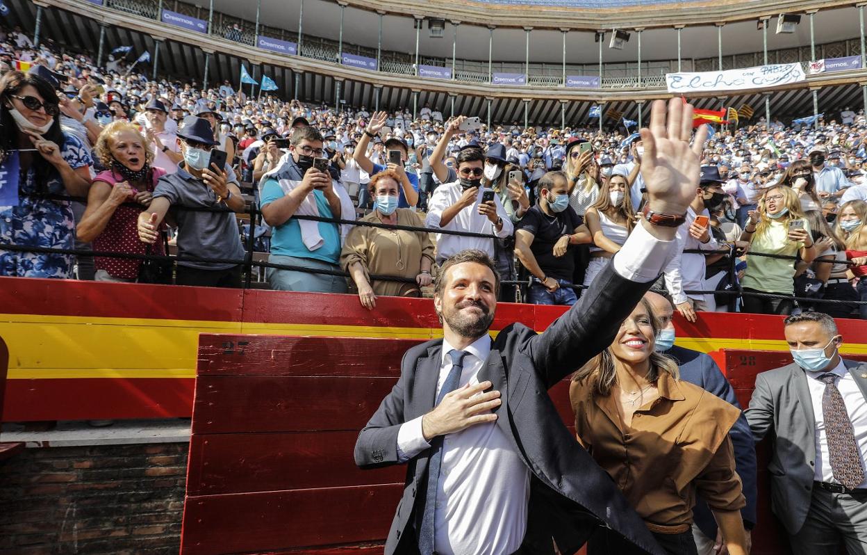 Pablo Casado, acompañado por su esposa, Isabel Torres, saluda a los asistentes al cierre de la convención, en la plaza de toros de Valencia. 