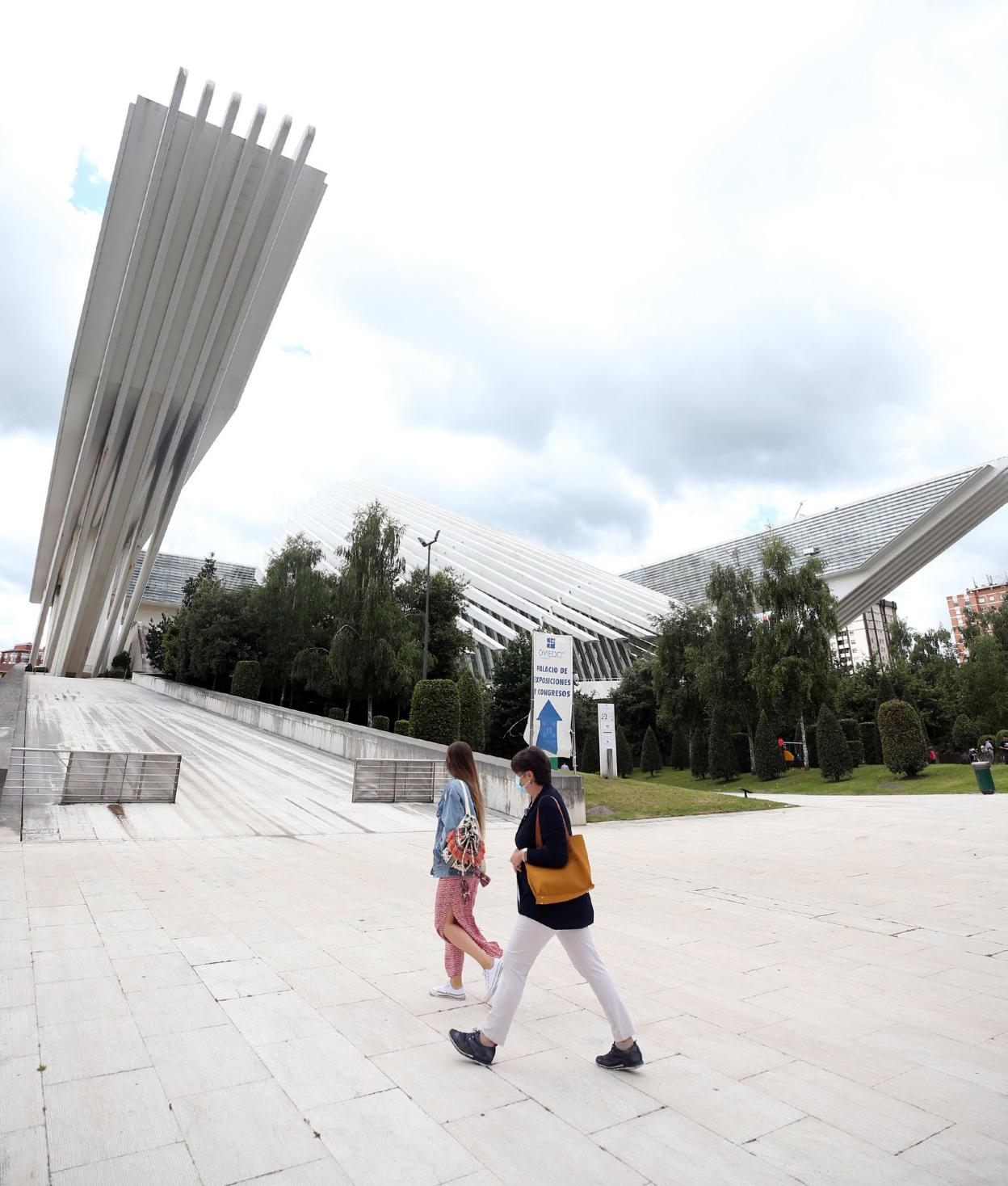 Dos mujeres caminan por delante del Palacio de Congresos. 