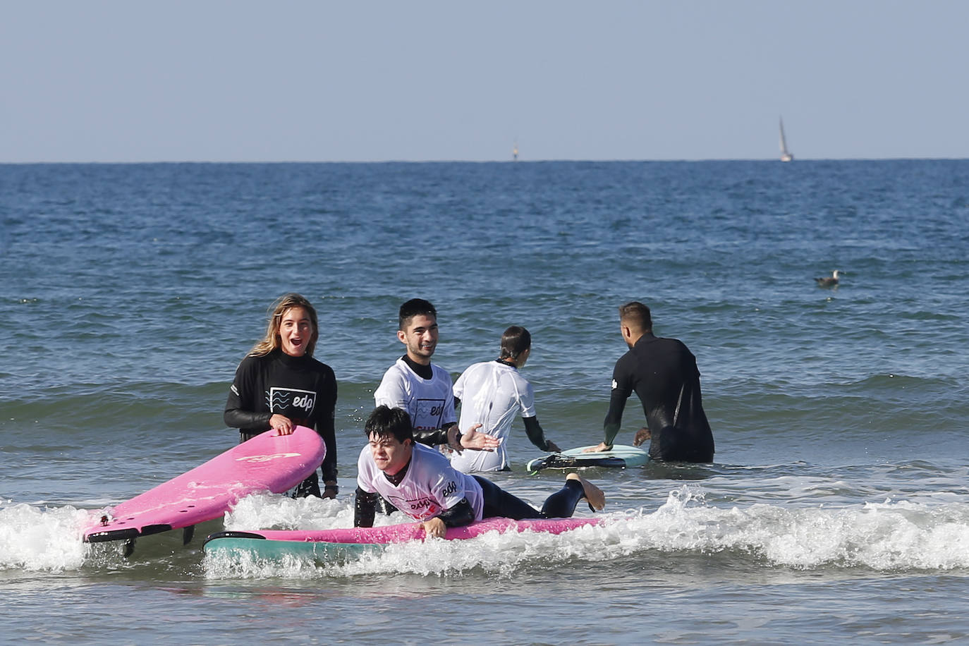 Una veintena de jóvenes con necesidades especiales han disfrutado este domingo de una colase de surf en el agua de la playa de San Lorenzo. La actividad, dedicada a miebros de la asociación Alarde y denominada 'Surf for Tomorrow', ha sido organizada por EdP y ha contado con la colaboración de la Escuela SkoolSurf. 