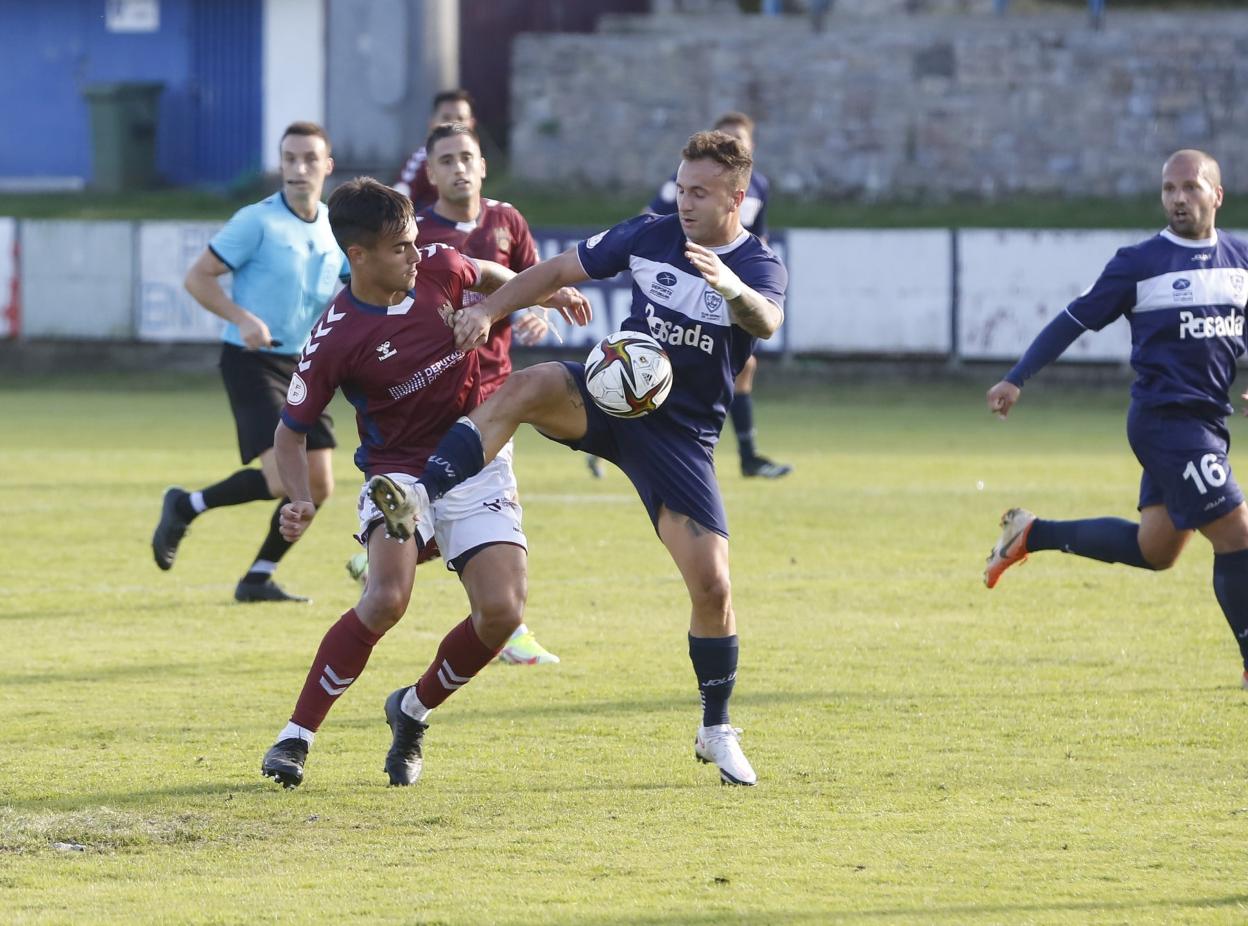 Iván Fernández, del Marino, disputa un balón a Miguel Román, del Pontevedra, en el partido disputado ayer en Miramar. 