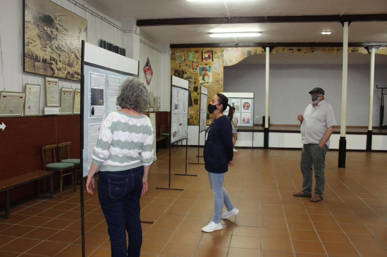 Esther Mocha, Begoña Junquera y José Manuel García, miembros de la CNT, contemplan la exposición. 