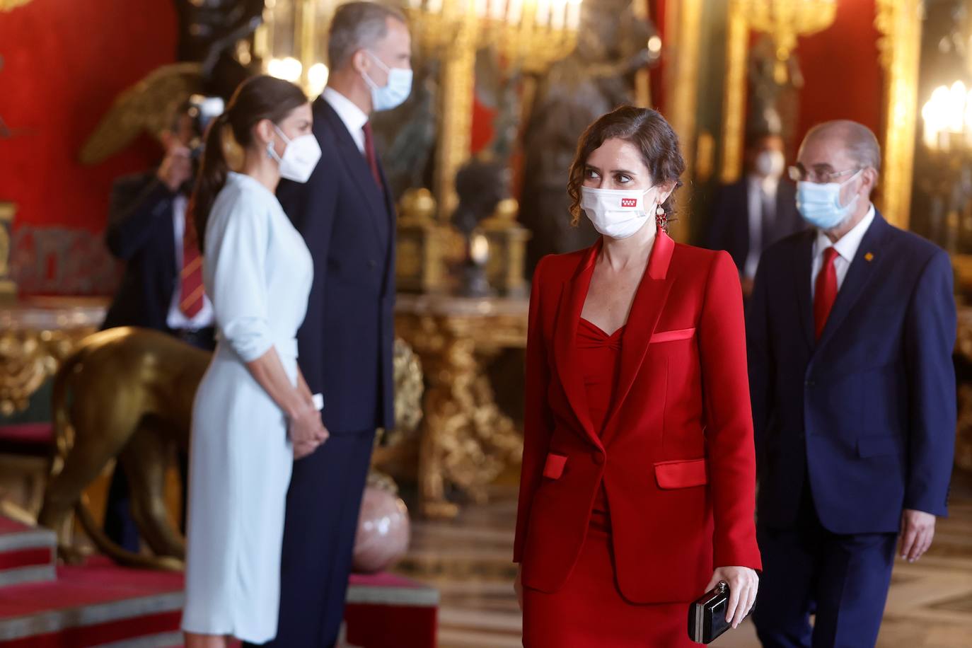 El Palacio Real de Madrid ha acogido la tradicional recepción que los Reyes ofrecen con motivo de la Fiesta Nacional y que el año pasado tuvo que suspenderse por la covid. Esta vez, el número inferior de invitados ha sido menor al habitual, unos 200, y ha sido imprescindible prescindir de bebidas y llevar la mascarilla para cumplir con las normas vigentes.