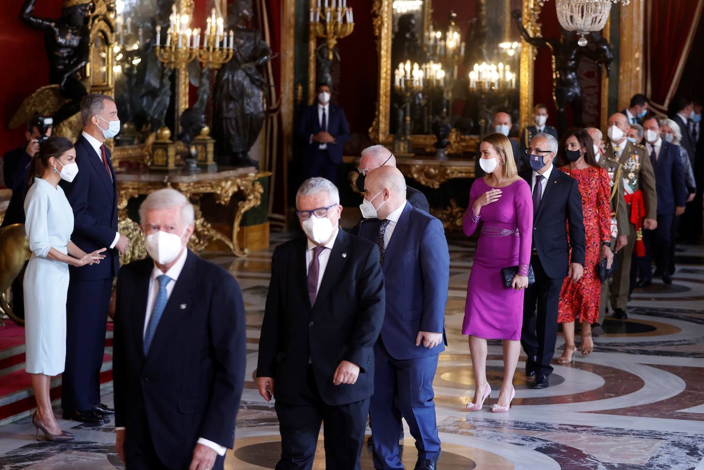 El Palacio Real de Madrid ha acogido la tradicional recepción que los Reyes ofrecen con motivo de la Fiesta Nacional y que el año pasado tuvo que suspenderse por la covid. Esta vez, el número inferior de invitados ha sido menor al habitual, unos 200, y ha sido imprescindible prescindir de bebidas y llevar la mascarilla para cumplir con las normas vigentes.