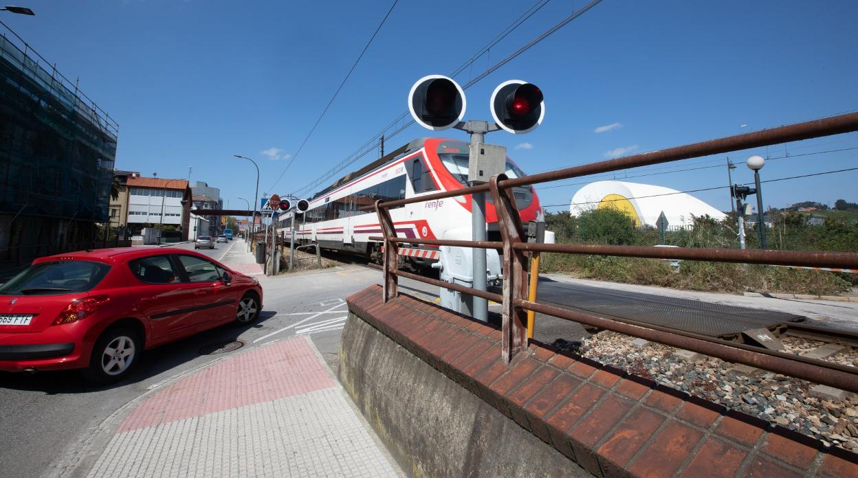 Un tren de Renfe cruza en el paso a nivel de la calle del Muelle. 