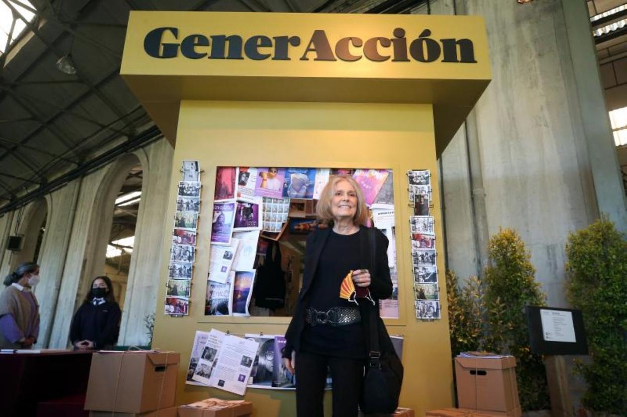 Gloria Steinem frente al stand 'GenerAcción' con los trabajos expuestos. 