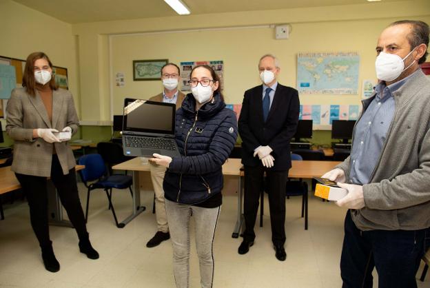 Ana María Abad, Javier Cueli, Ángel Moraleda, Tomás Fernández y Belén López, madre de un alumno, recibiendo un ordenador portatil. / E.C.
