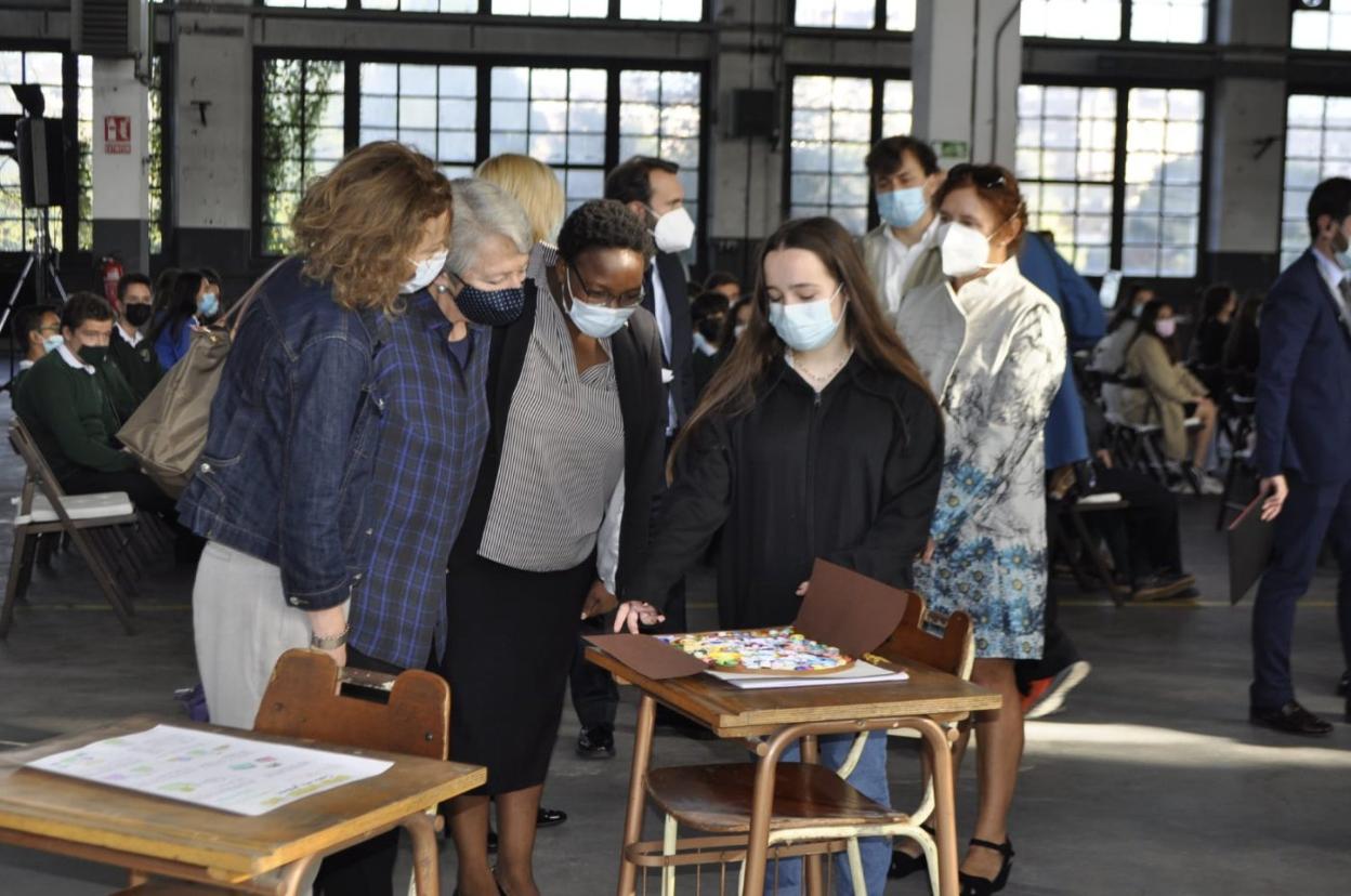 Una alumna explica el proyecto a las representantes de Camfed. 