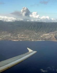 Imagen secundaria 2 - Dos miembros de la UME; el volcán durante la noche; y vista del volcán desde un avión.