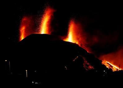 Imagen secundaria 1 - Dos miembros de la UME; el volcán durante la noche; y vista del volcán desde un avión.