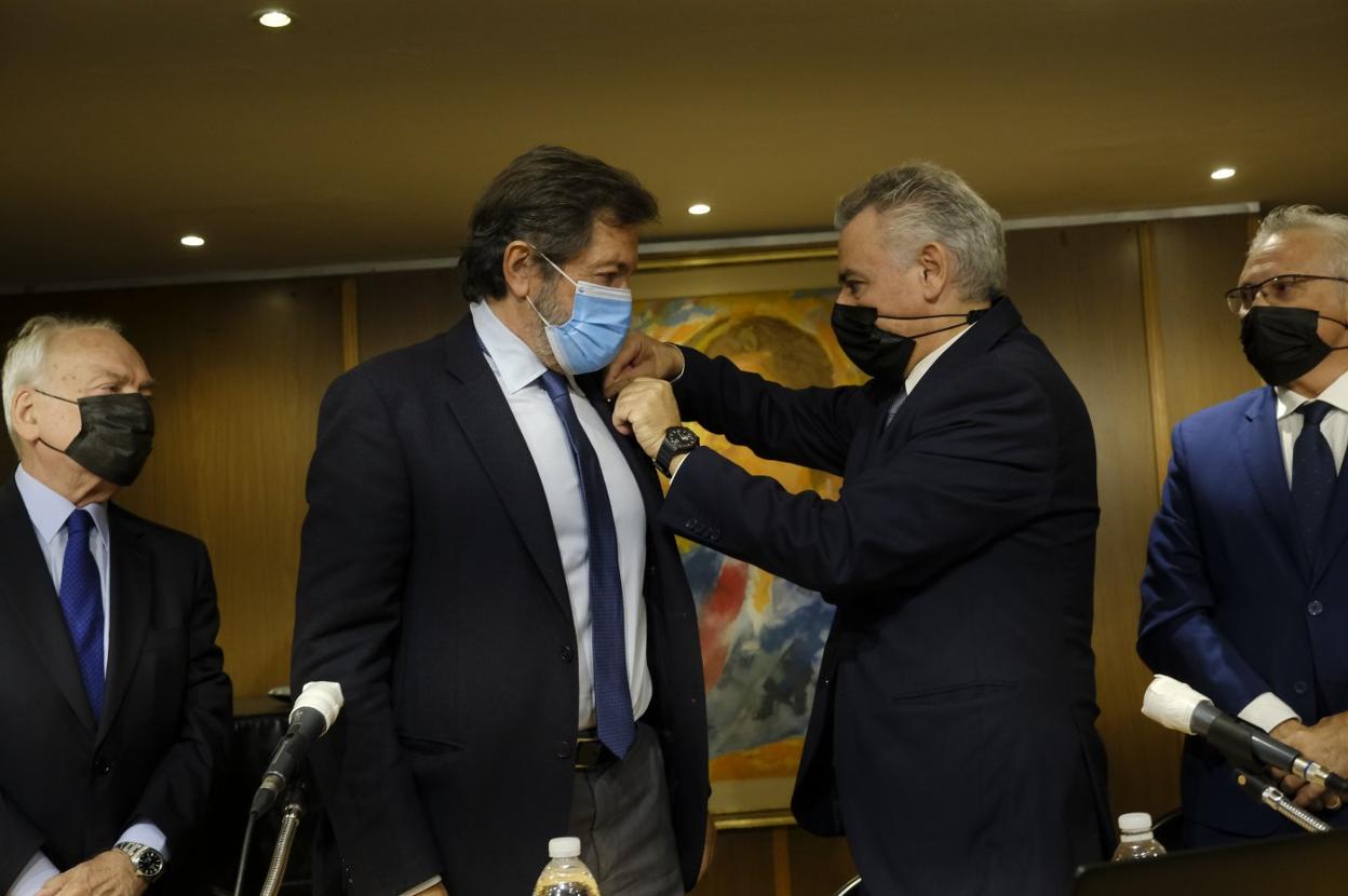 El presidente del Centro Asturiano en Madrid, Valentín Martínez-Otero coloca la distinción al expresidente regional, Javier Fernández, ante la atenta mirada del también expresidente, Antonio Trevín, ayer, en Madrid. 