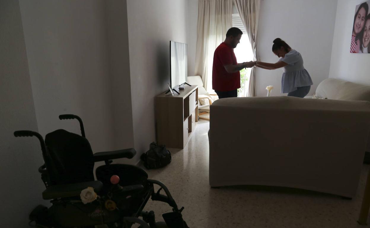 Una enferma de la ELA en su casa, en Sevilla, junto a su pareja.