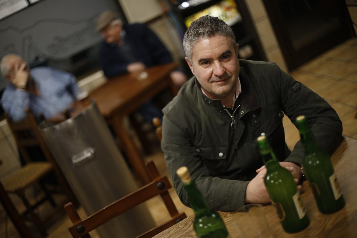 Luis Benito García, ante tres botellas de sidra, en una sidrería. 