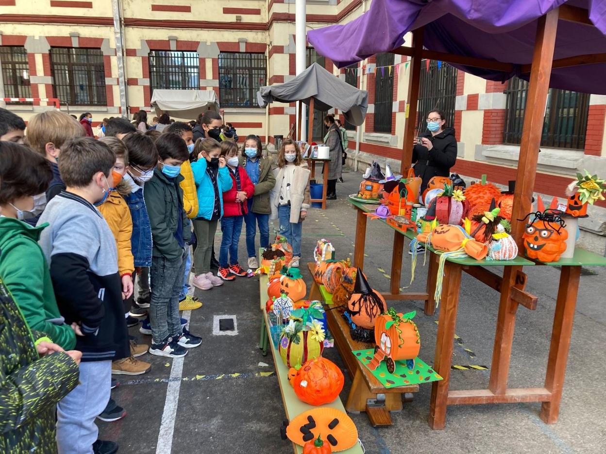 Un grupo de alumnos mira la muestra de calabazas. 