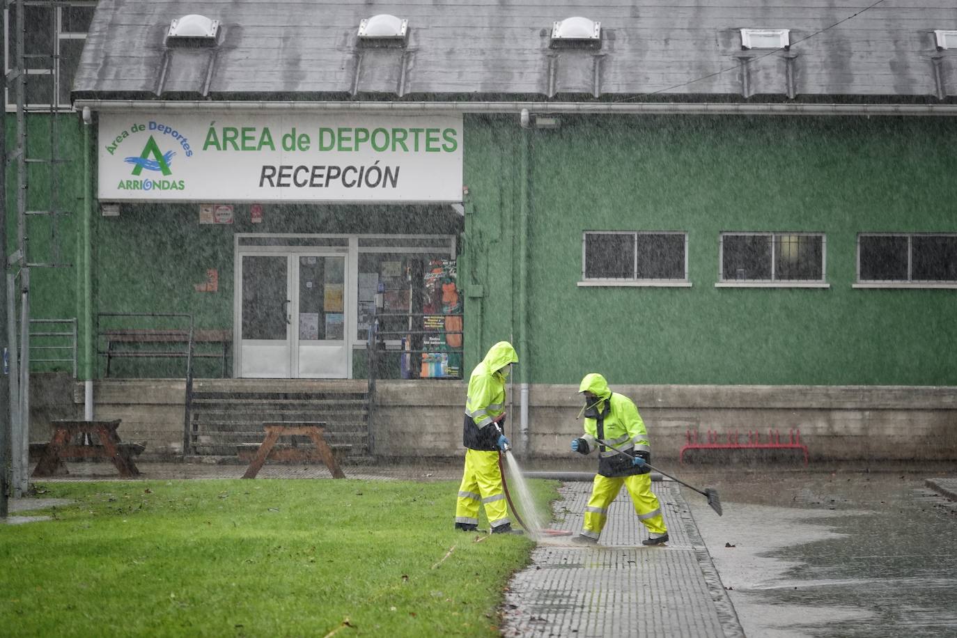 Los concejos afectados por las fuertes lluvias tratan de recuperarse de los estragos causados por el temporal. Con las treguas intermitentes que están concediendo las precipitaciones, bomberos y vecinos se afanan en limpiar los destrozos que el agua provocó en las últimas horas. En Arriondas, los esfuerzos se centran tanto en la zona escolar y el barrio de El Barco como en la deportiva, donde ha sido una mañana de limpieza y retirada del barro.