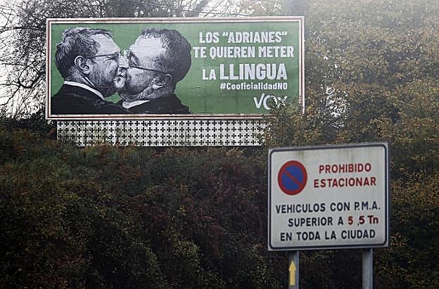 Valla de la campaña de Vox instalado en las inmediaciones del polígono del Espíritu Santo, en Oviedo. La imagen recuerda a la histórica foto (a la derecha) del beso entre Breznev y Hoenecker en 1979. 