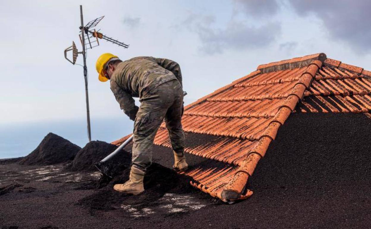 Retirada de cenizas de una casa afectada por el volcán de La Palma. 