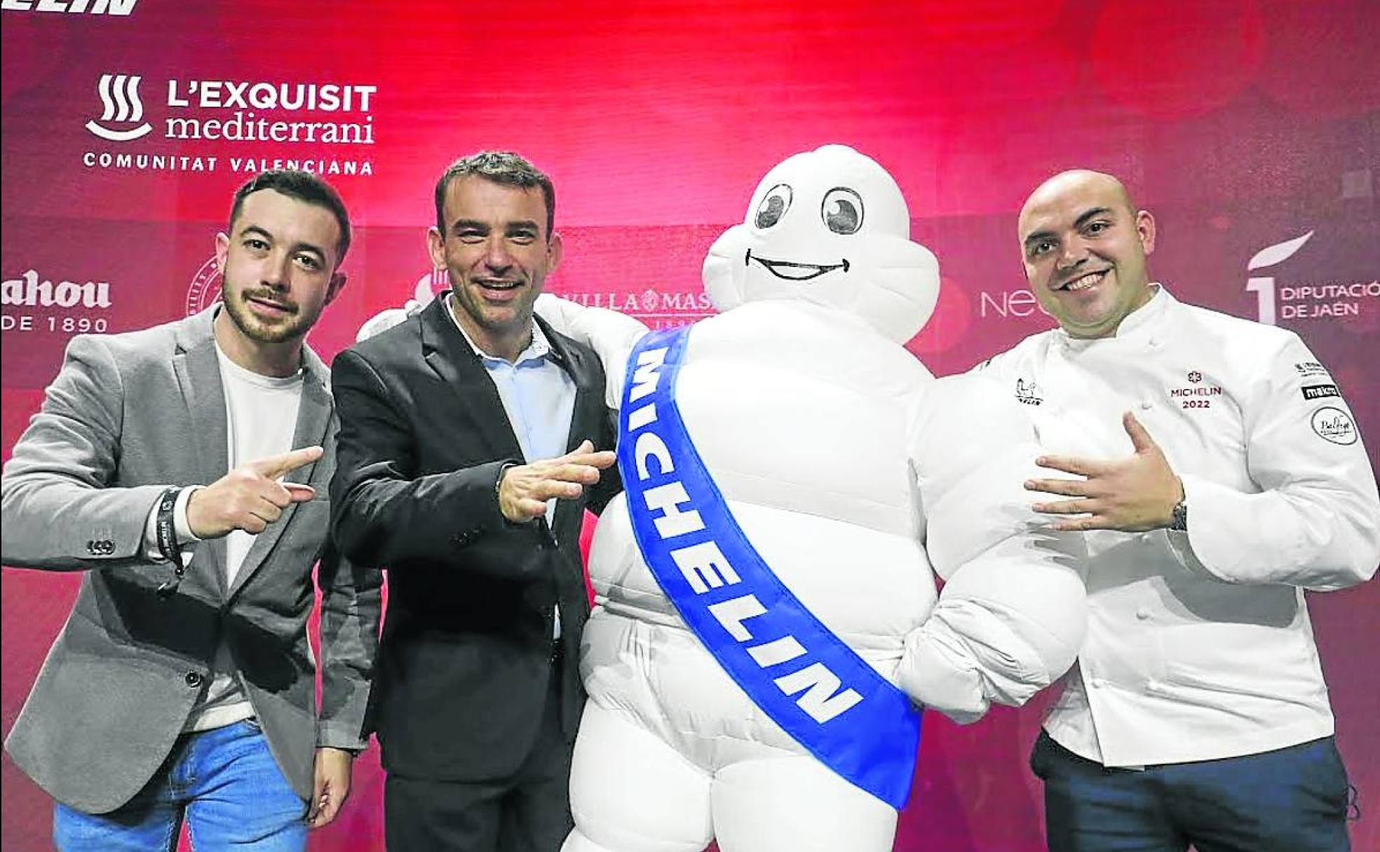 José Miranda, Marcos Granda e Israel Moreno, con el muñeco de la guía Michelin, en Valencia. 