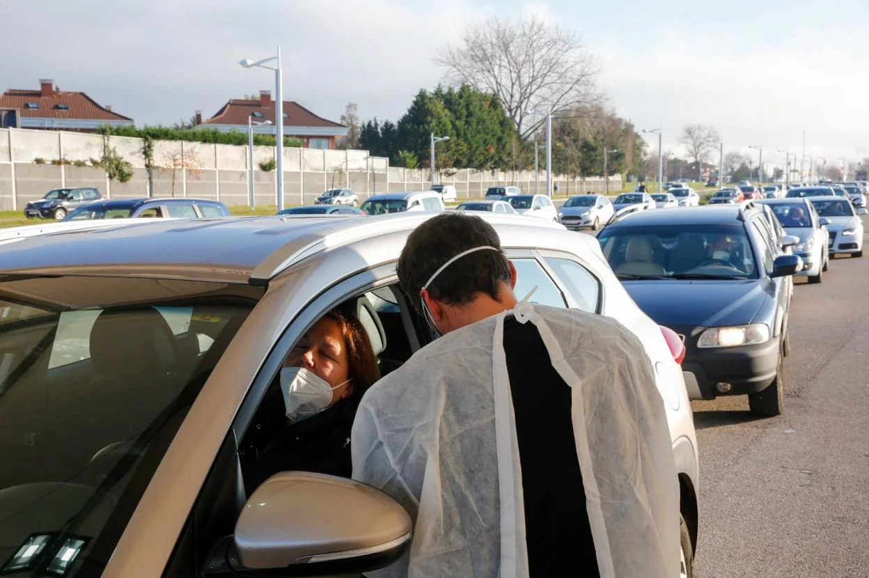 Un sanitario practica una prueba PCR a una mujer en el autocovid instalado ante Marina Civil, en Gijón. 